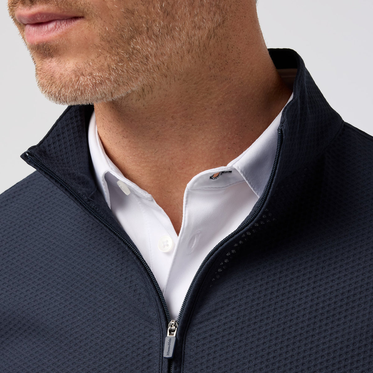 Close-up of Mizzen and Main Easton Quarter Zip in navy worn over white collared shirt