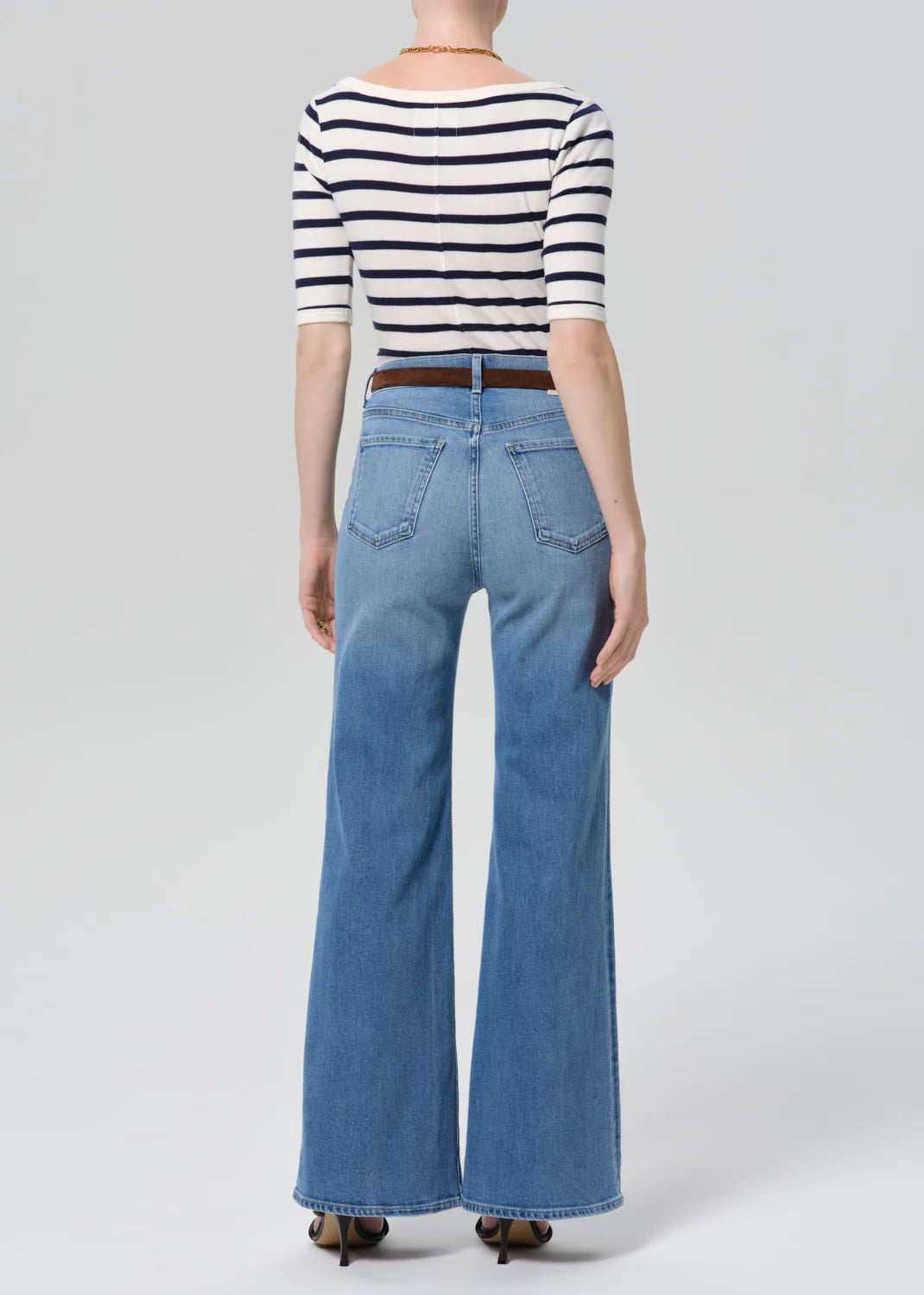 Citizens of Humanity Kimberly Patch Pocket Flare jeans in medium wash denim, shown from behind with striped top and brown ...