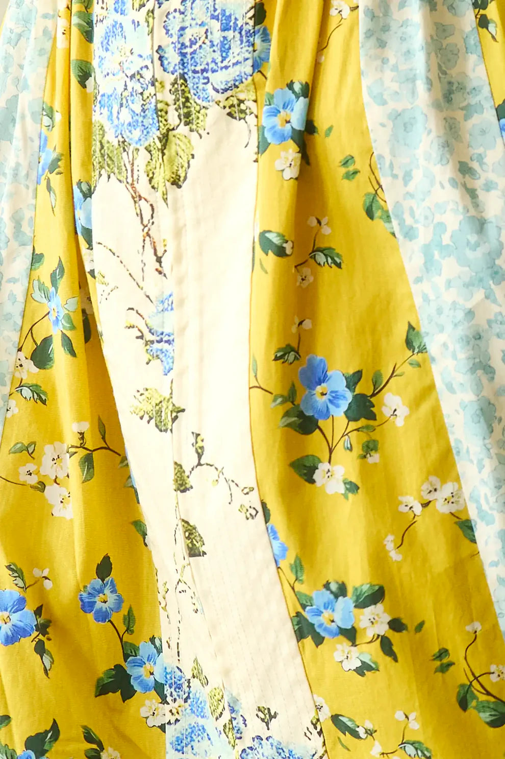 Hunter Bell April Dress featuring flowing fabric with blue floral print on yellow background and mixed botanical patterns.
