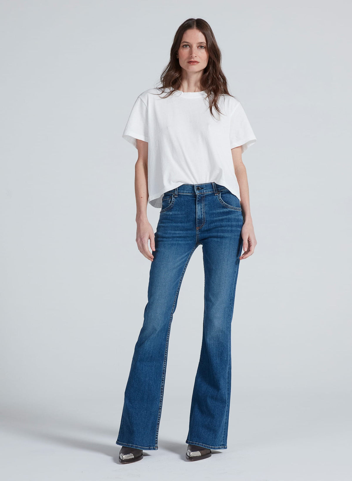 Model wearing ASKK NY Bond Street bootcut jeans in medium blue wash with white tee