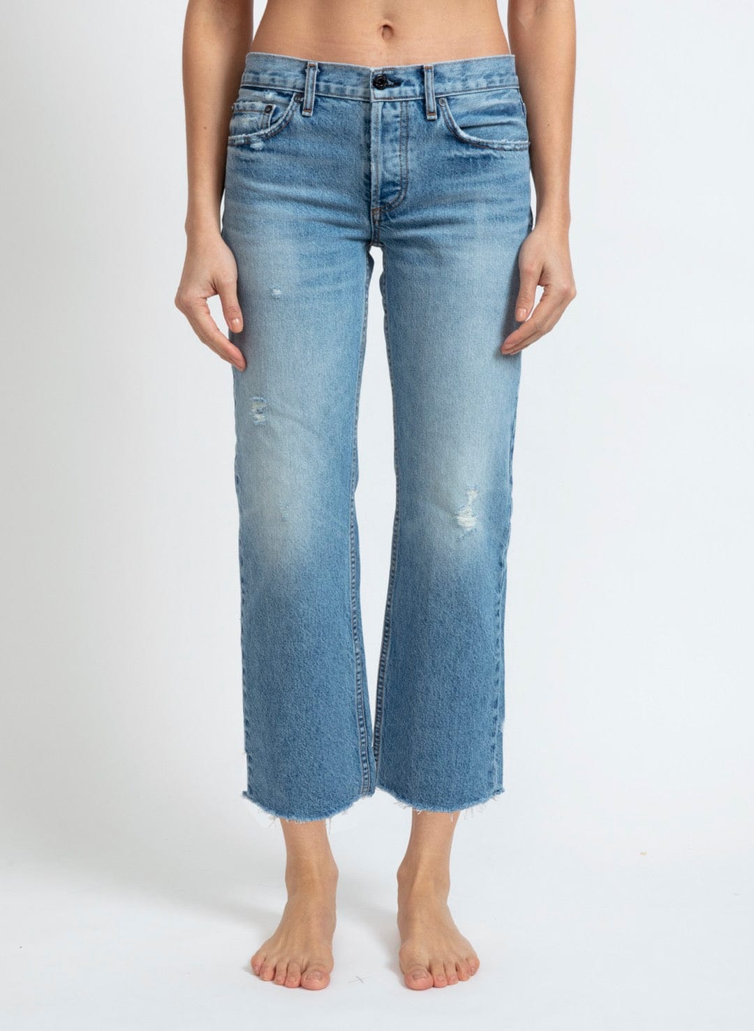 Model wearing ASKK NY low rise straight leg jeans in light blue Berkeley wash