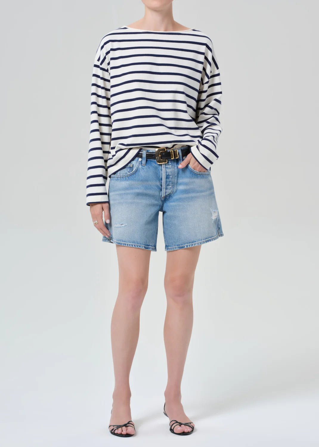 Citizens of Humanity Billie Relaxed Short in light wash denim with distressed details, styled with striped top and belt.