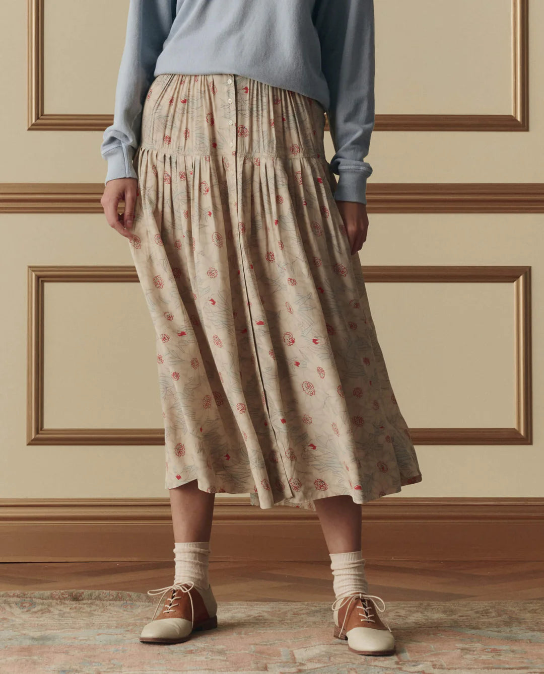 The Great Highland midi skirt in champagne with scattered floral print, featuring button-front closure and tiered silhouette.