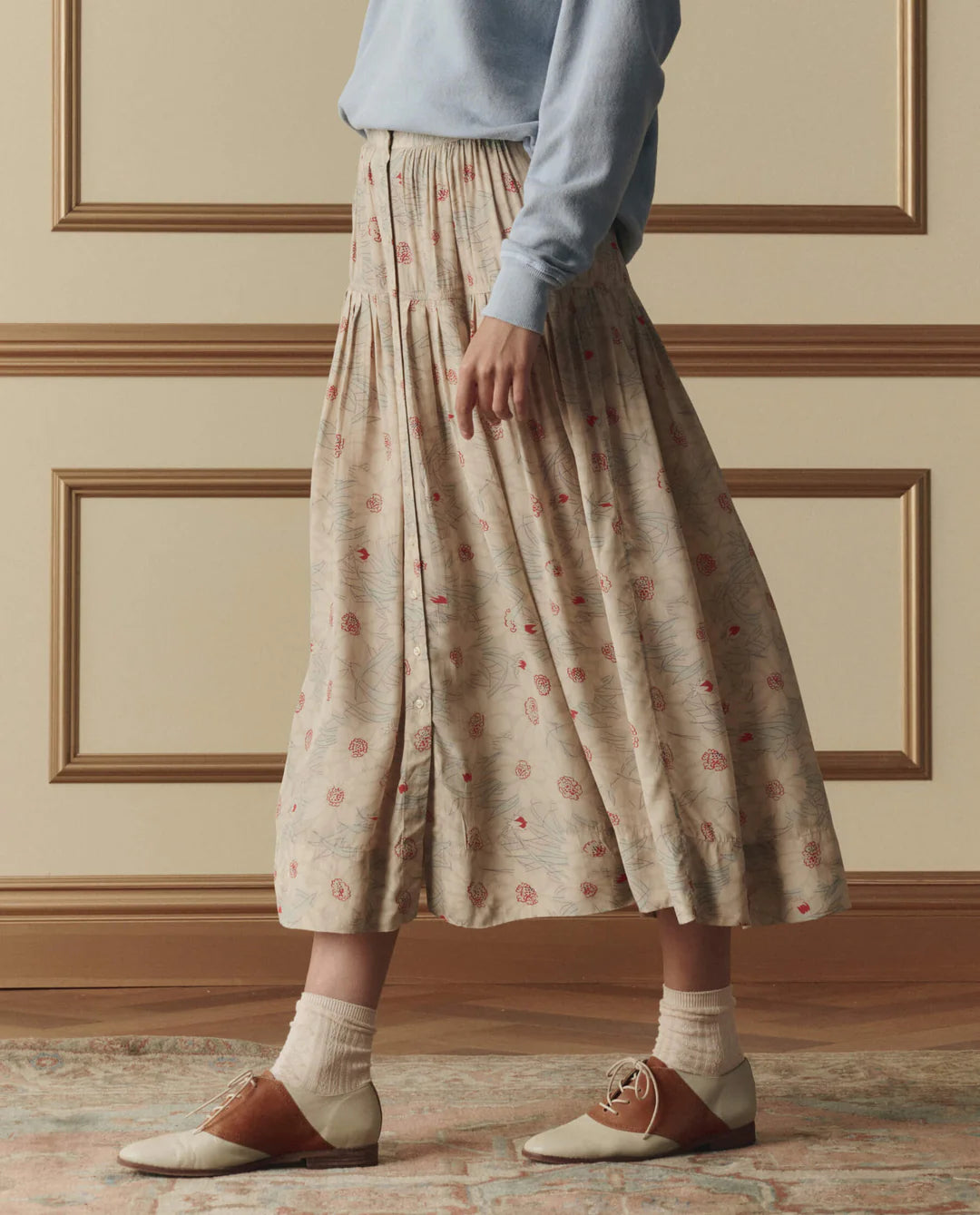 The Great Highland midi skirt in champagne with scattered floral print, featuring elastic waist and tiered ruffle hem.