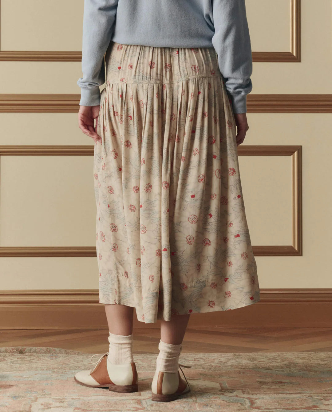 The Great Highland midi skirt in champagne with scattered floral print, featuring elastic waistband and tiered construction.