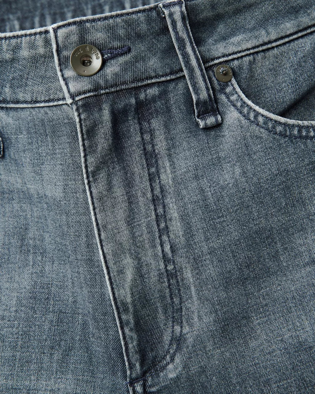 Close-up detail of Rag & Bone denim jeans showing pocket, waistband, button closure and stitching construction.