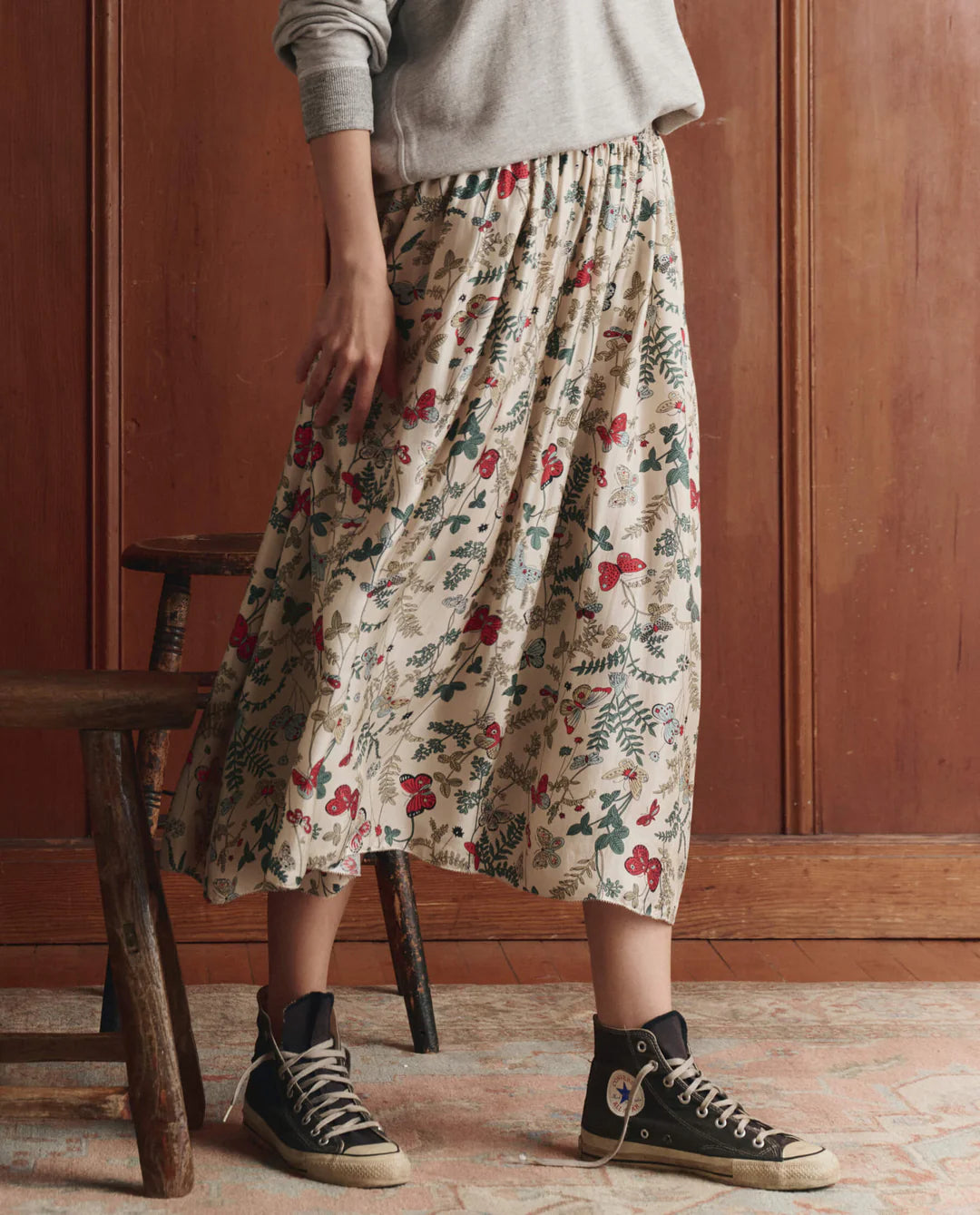 Person wearing The GREAT The Canary Skirt with botanical butterfly print, featuring a flowing midi-length silhouette and e...