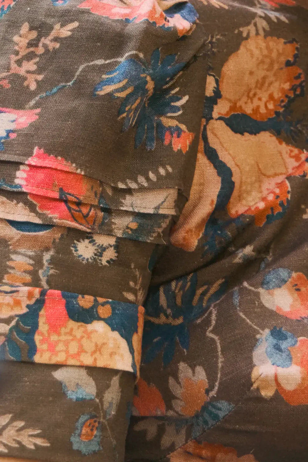 Hunter Bell Casey Dress featuring vibrant floral print on olive fabric with draped, flowing textile detail.
