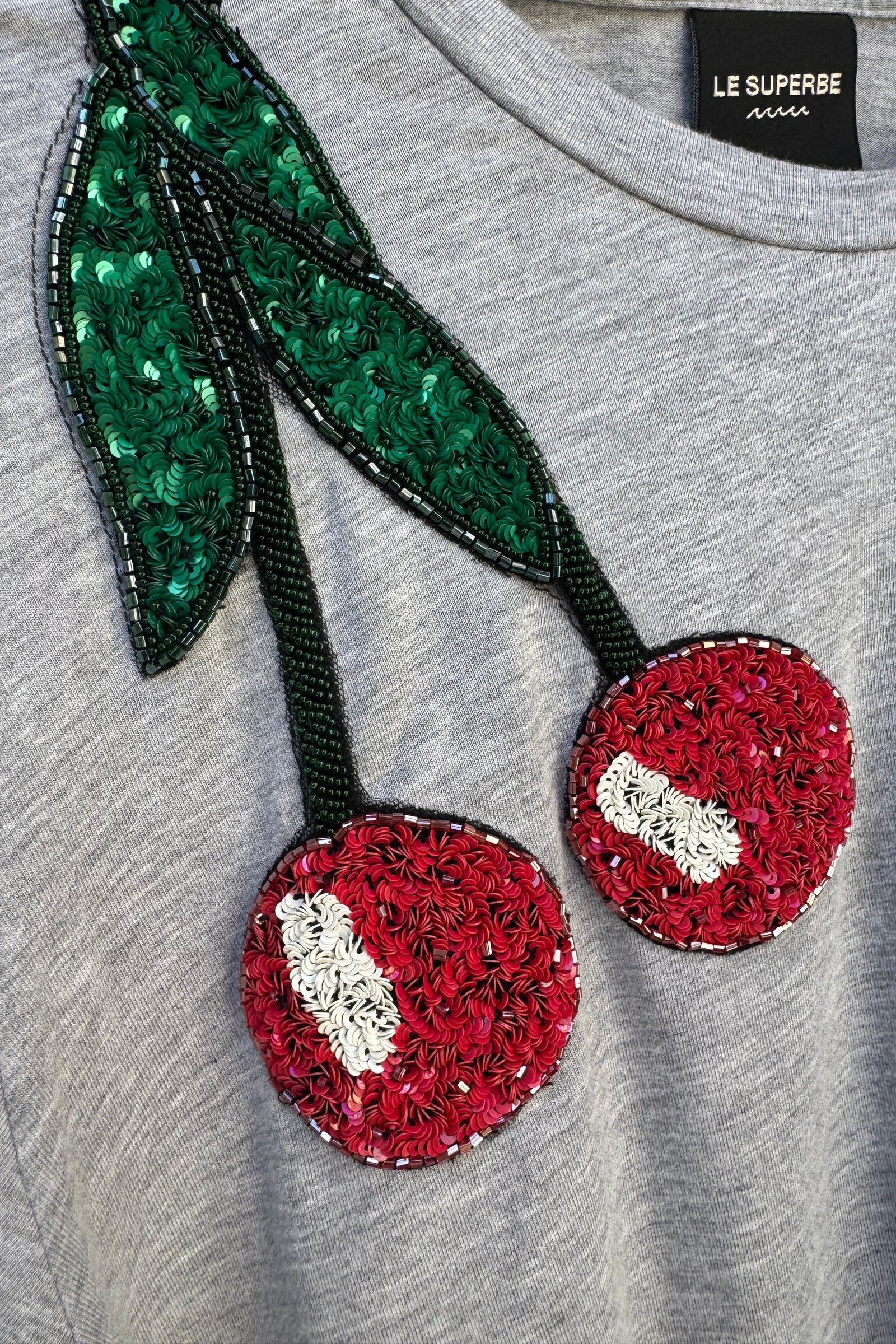 Le Superbe heather grey t-shirt featuring sequined cherry embellishment with red fruit and green leaves