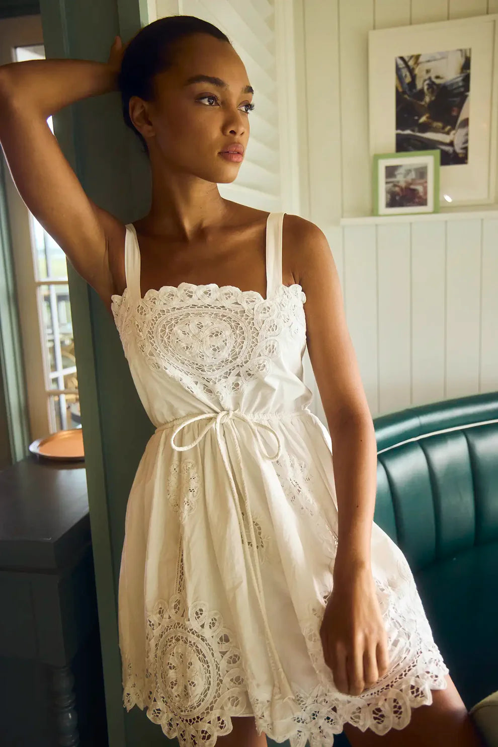 Hunter Bell Cosette white lace dress with eyelet embroidery, tie waist, and scalloped hem detail on model.