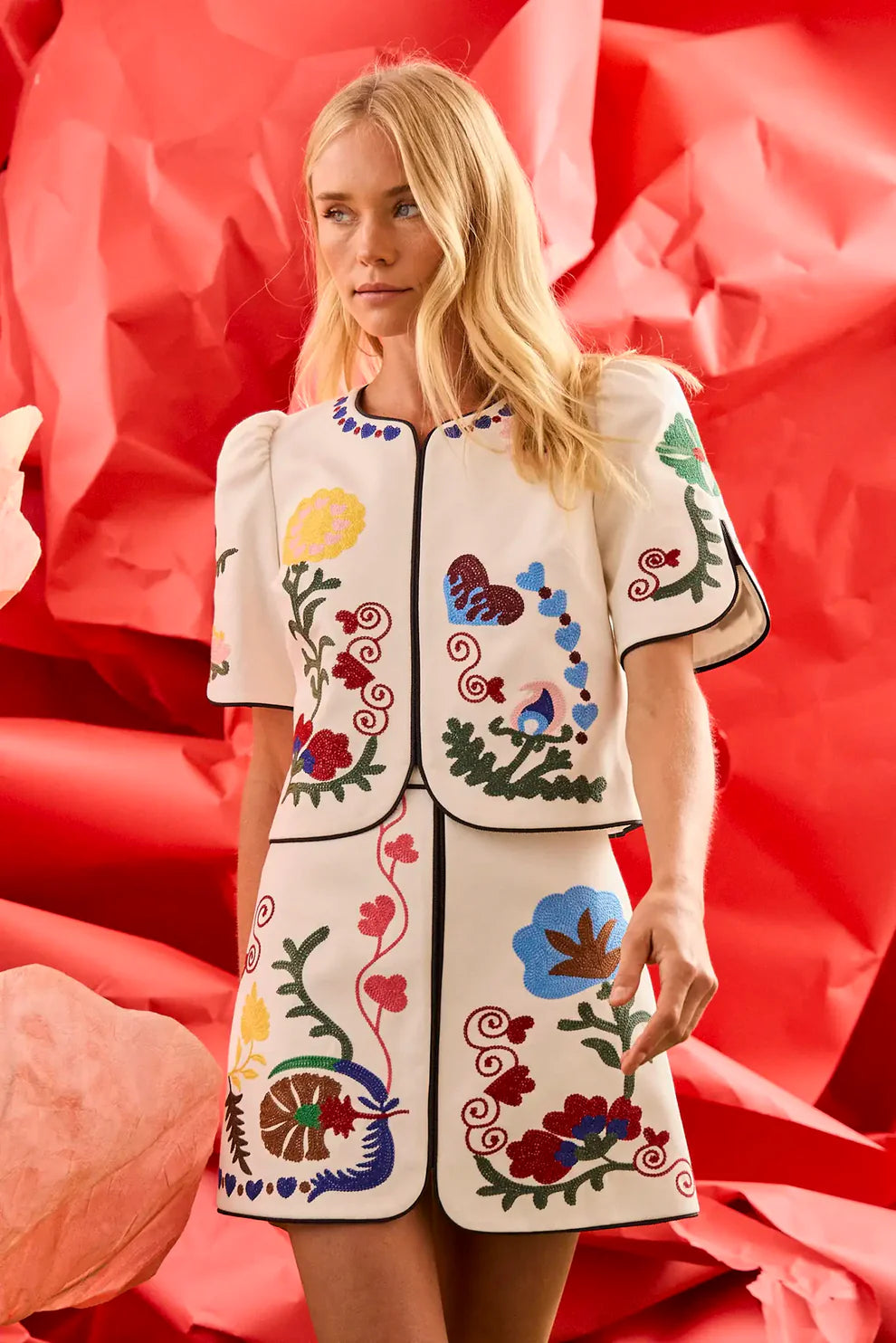 Hunter Bell Dottie embroidered white mini skirt with colorful floral motifs and black piping detail.