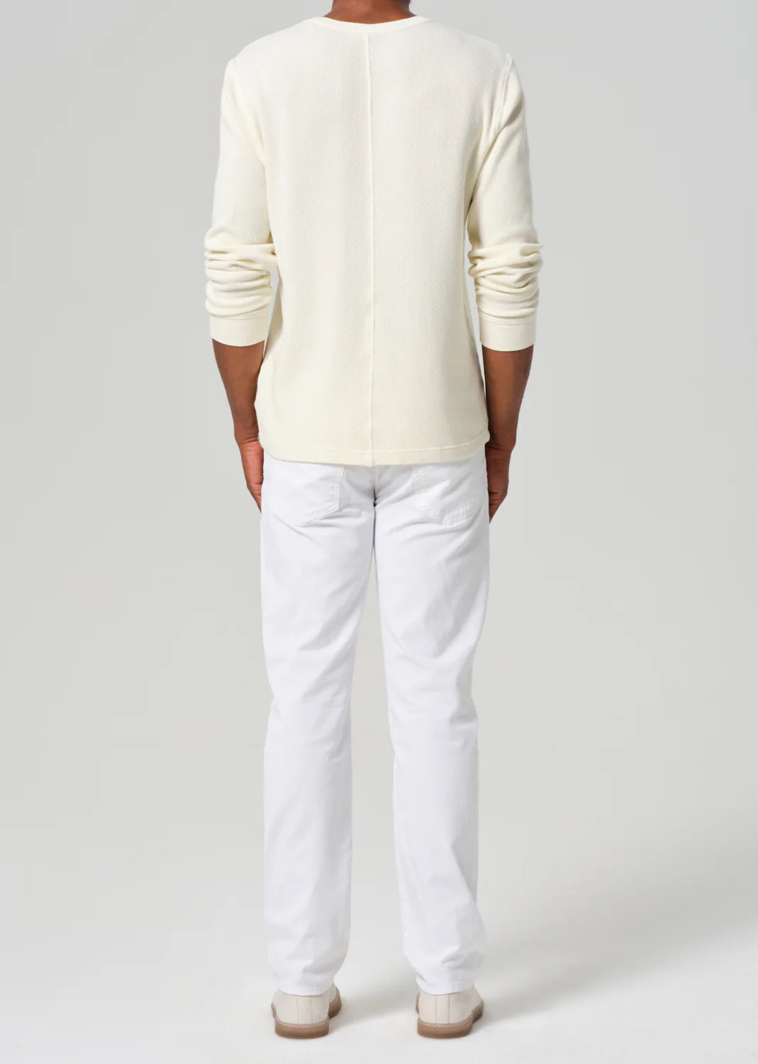 Citizens of Humanity Elijah white stretch linen pants shown from behind on male model with cream long-sleeve shirt