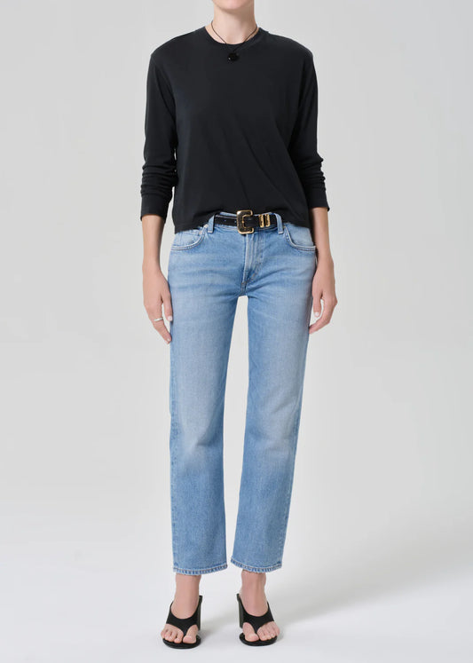 Woman wearing Citizens of Humanity Anissa jeans in Flutter wash with black long-sleeve top and belt