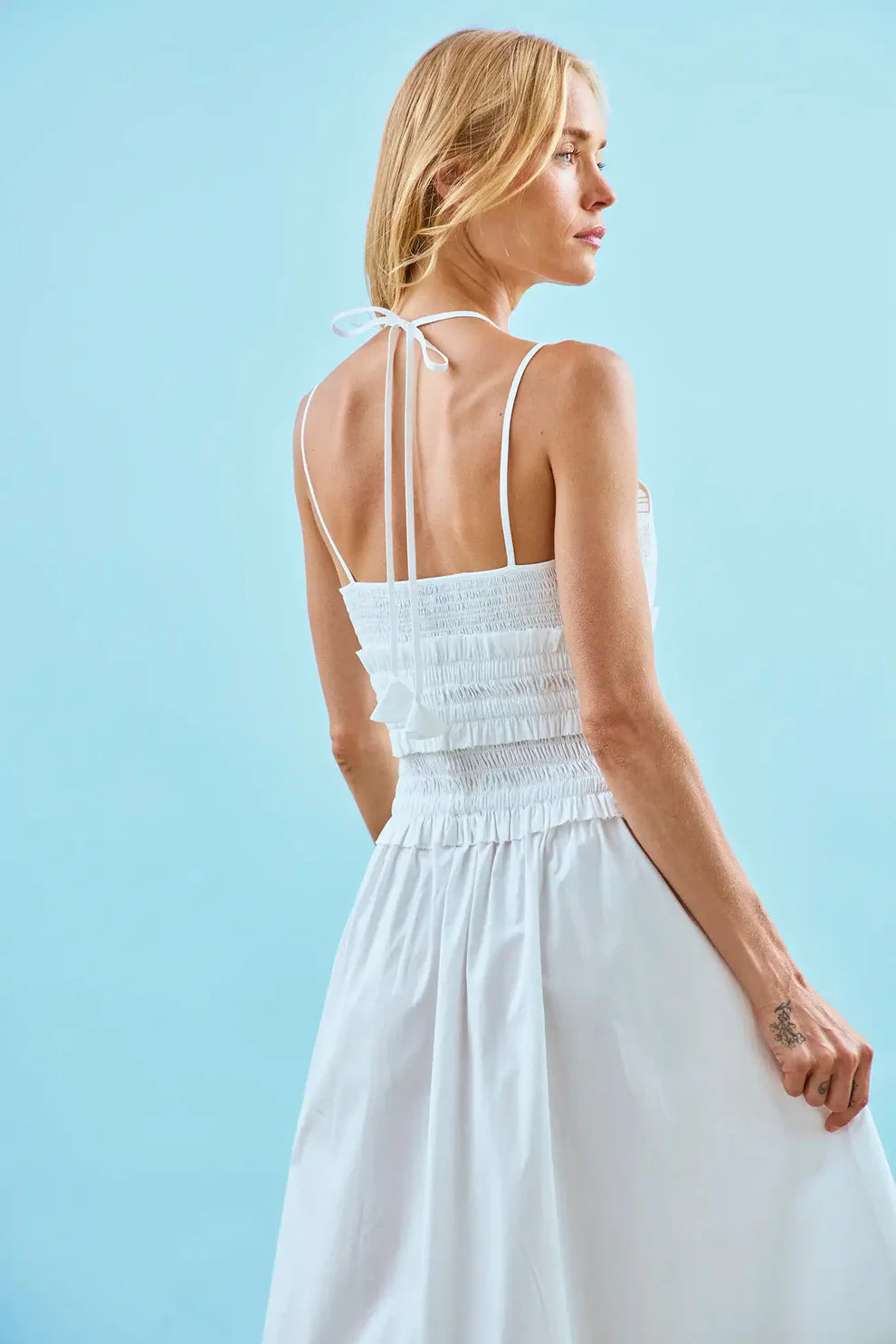 Hunter Bell Francie white dress with smocked bodice, tie straps, and flowing skirt shown from behind.
