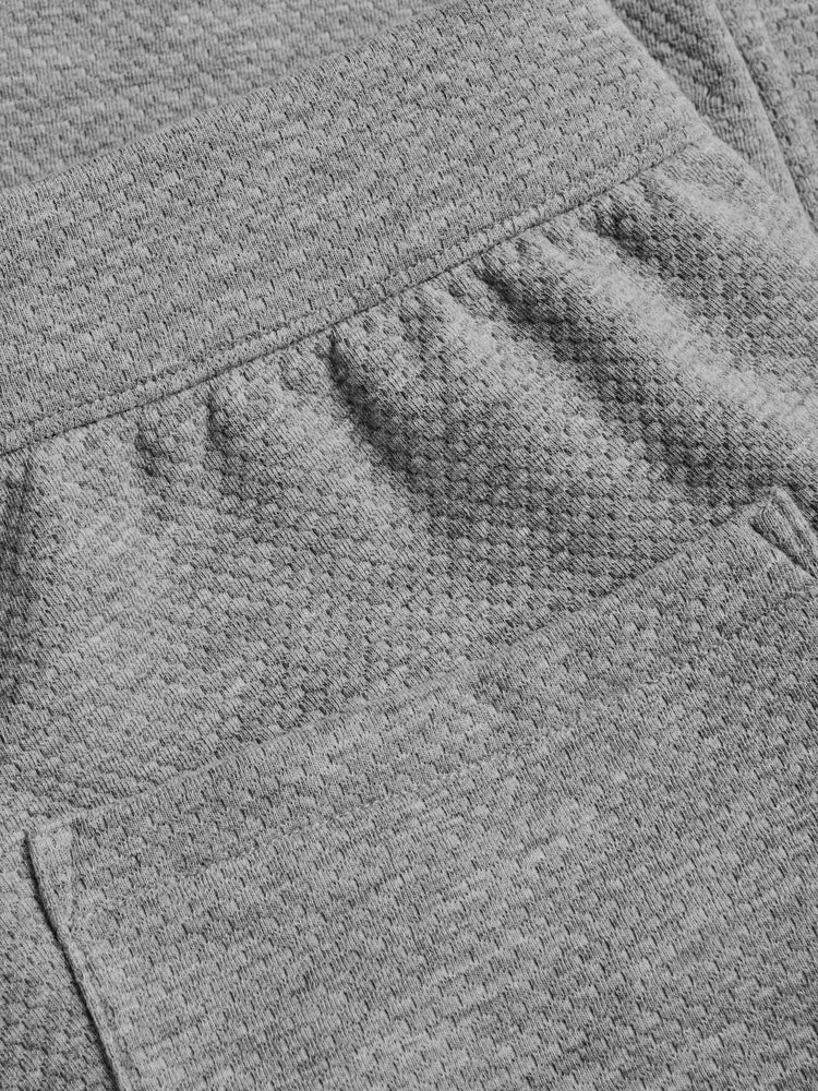 Close-up detail of grey heather textured jogger waistband and pocket construction