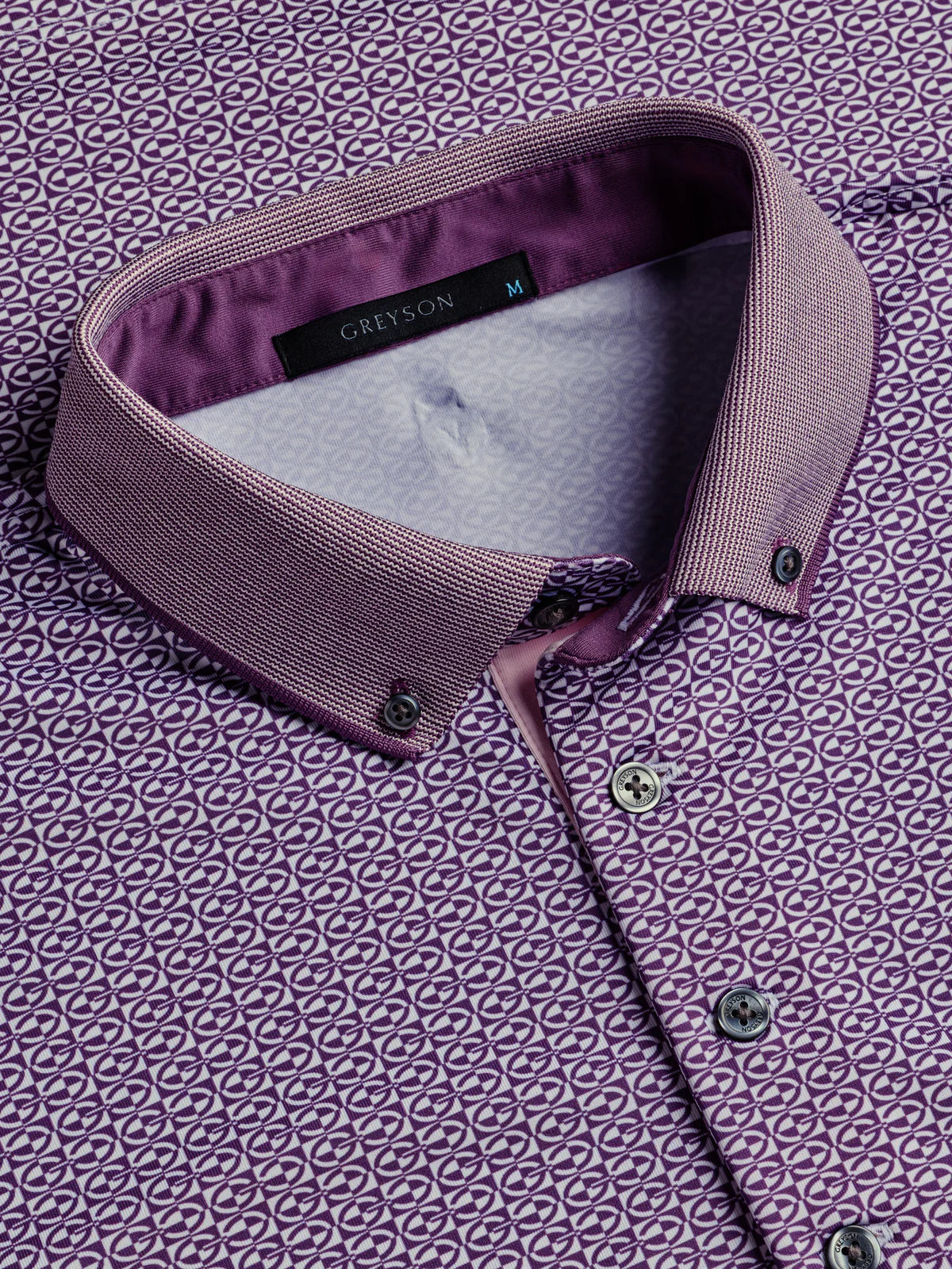 Greyson Guardian polo shirt with geometric print pattern, featuring button placket and contrasting collar detail.
