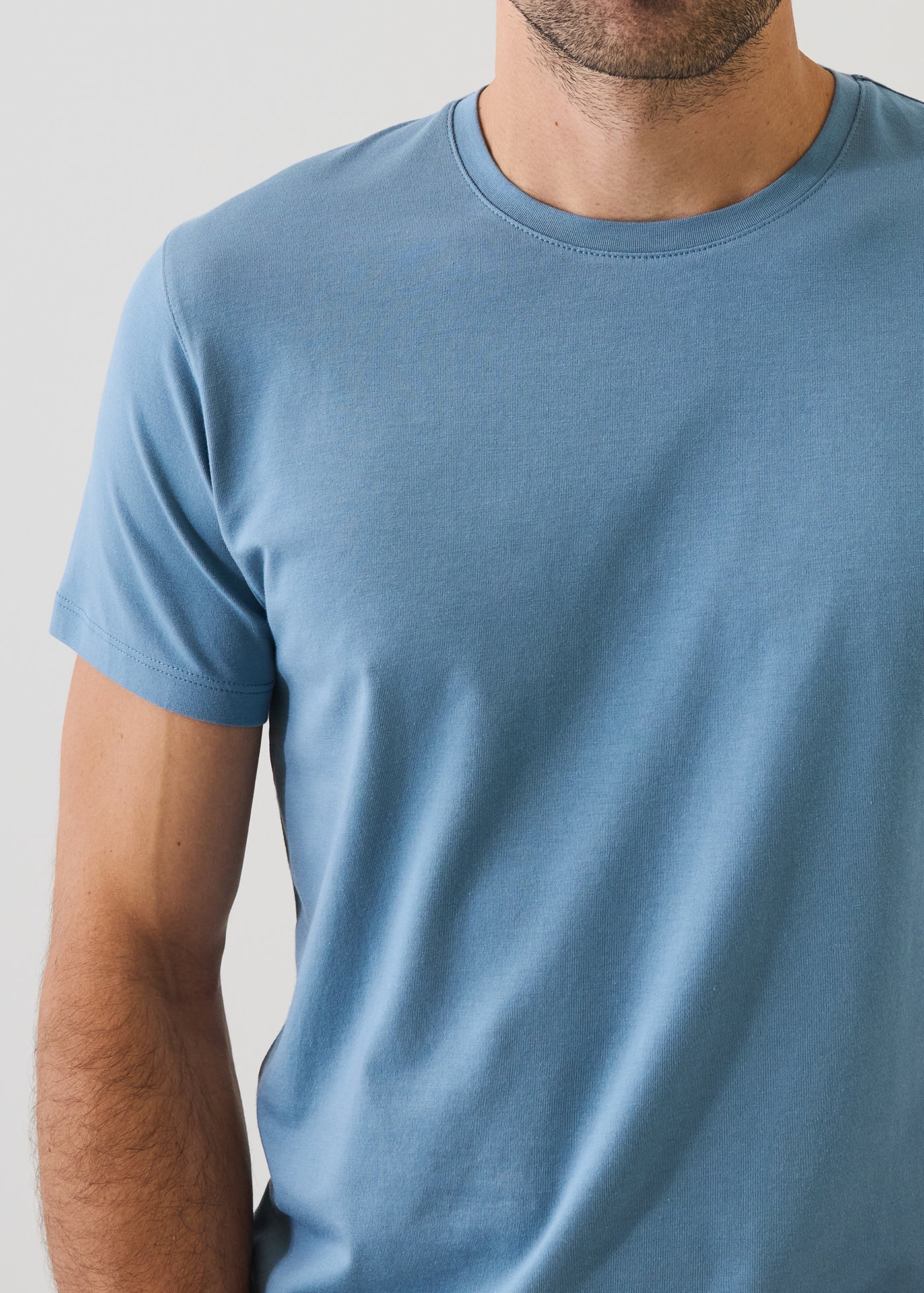 Patrick Assaraf short sleeve crew neck t-shirt in haze blue, shown on male model from chest down.