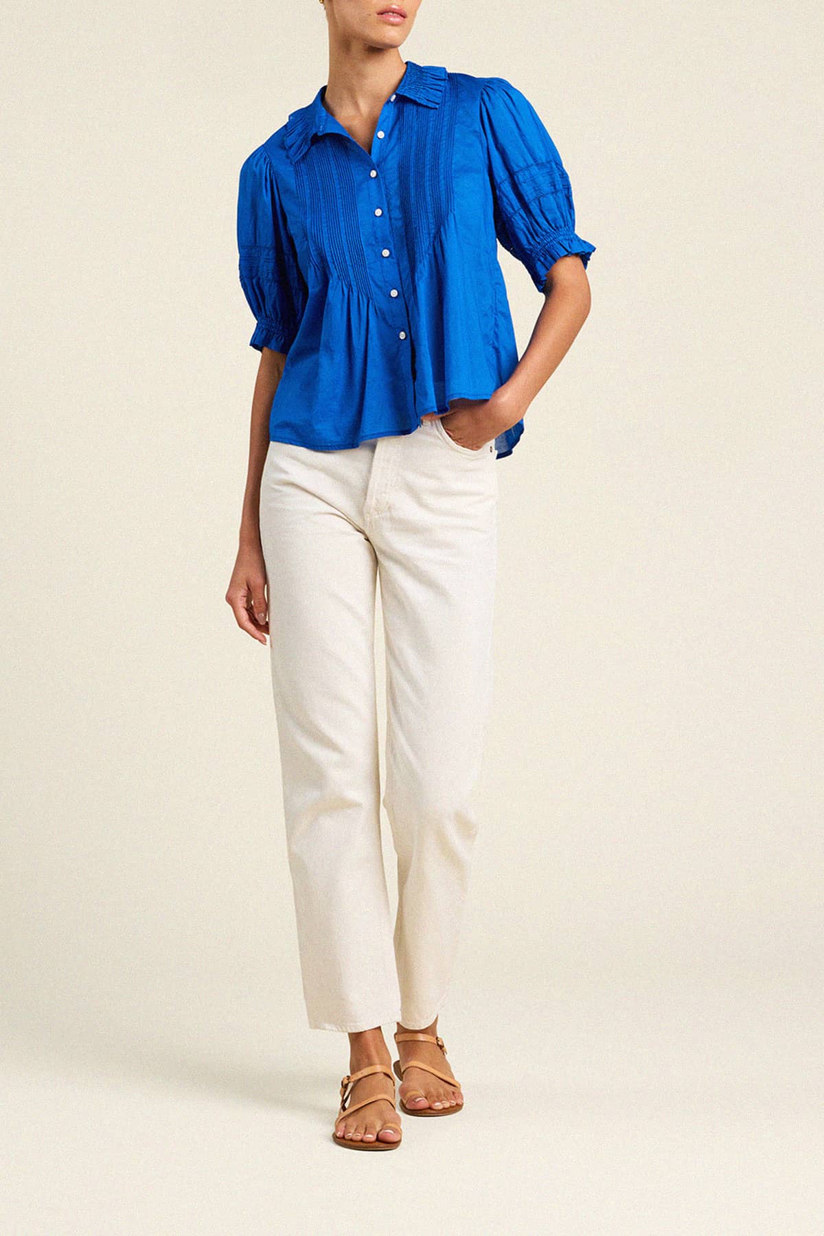 Trovata Jess blue puff sleeve blouse with white buttons paired with cream pants and brown sandals