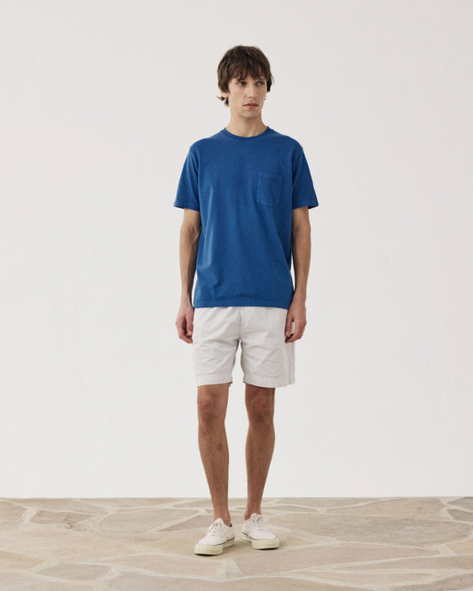 Man wearing Hartford blue crew neck t-shirt with white Joggy Short Flax casual shorts and white sneakers.
