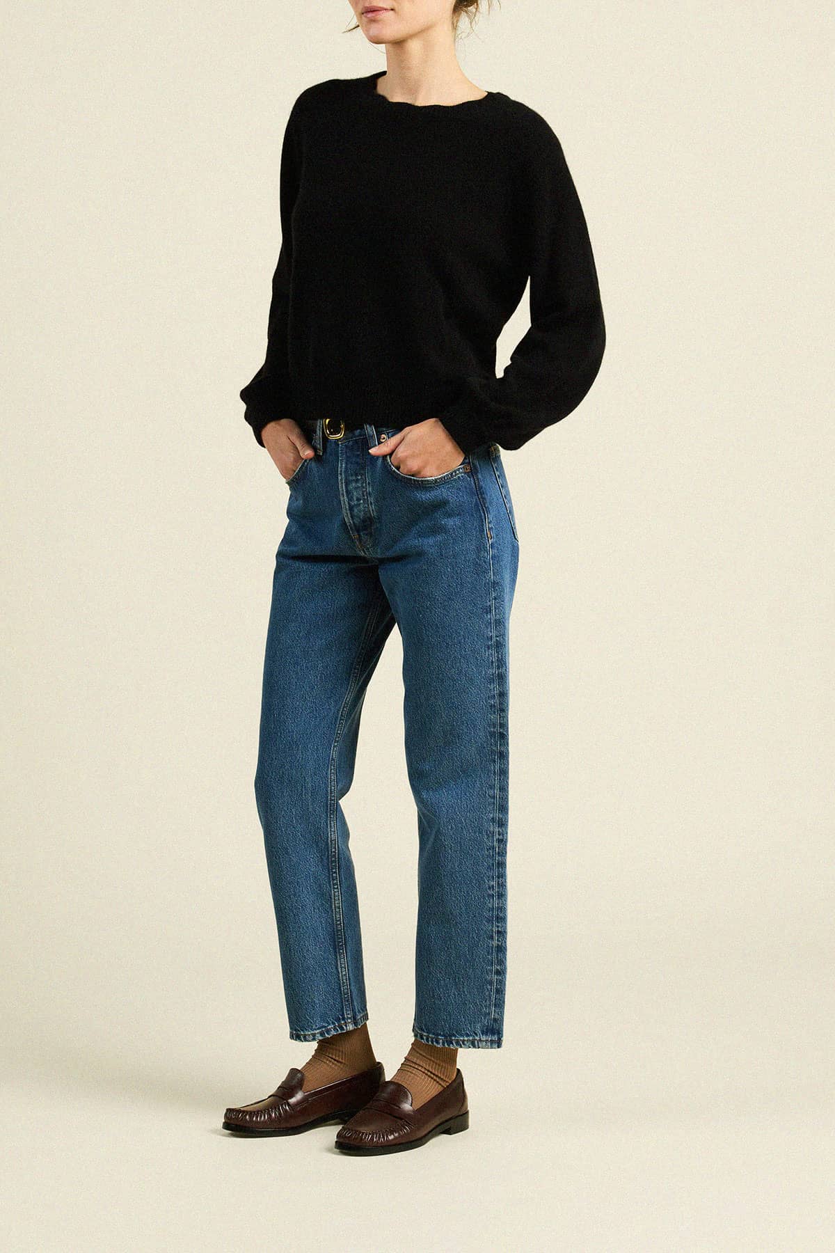 Trovata Kate black crewneck sweater with long sleeves, styled with straight-leg blue jeans and brown loafers.