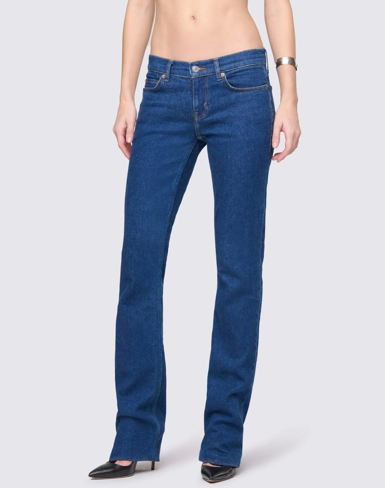 Re/Done women's straight-leg blue jeans with classic five-pocket styling and button fly closure, worn with black pointed-t...