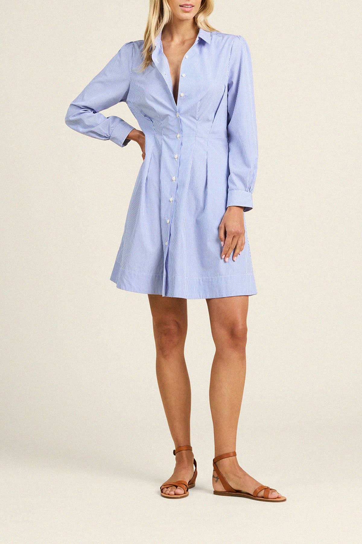 Trovata Lyra blue and white striped button-front shirt dress with long sleeves and collar, worn with brown sandals.