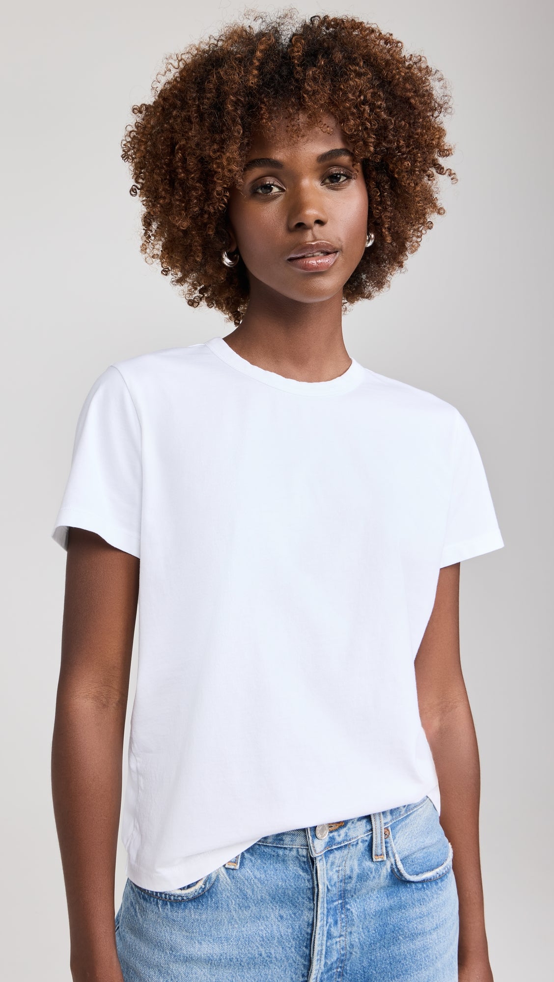 Woman wearing white short sleeve crew neck t-shirt with blue jeans