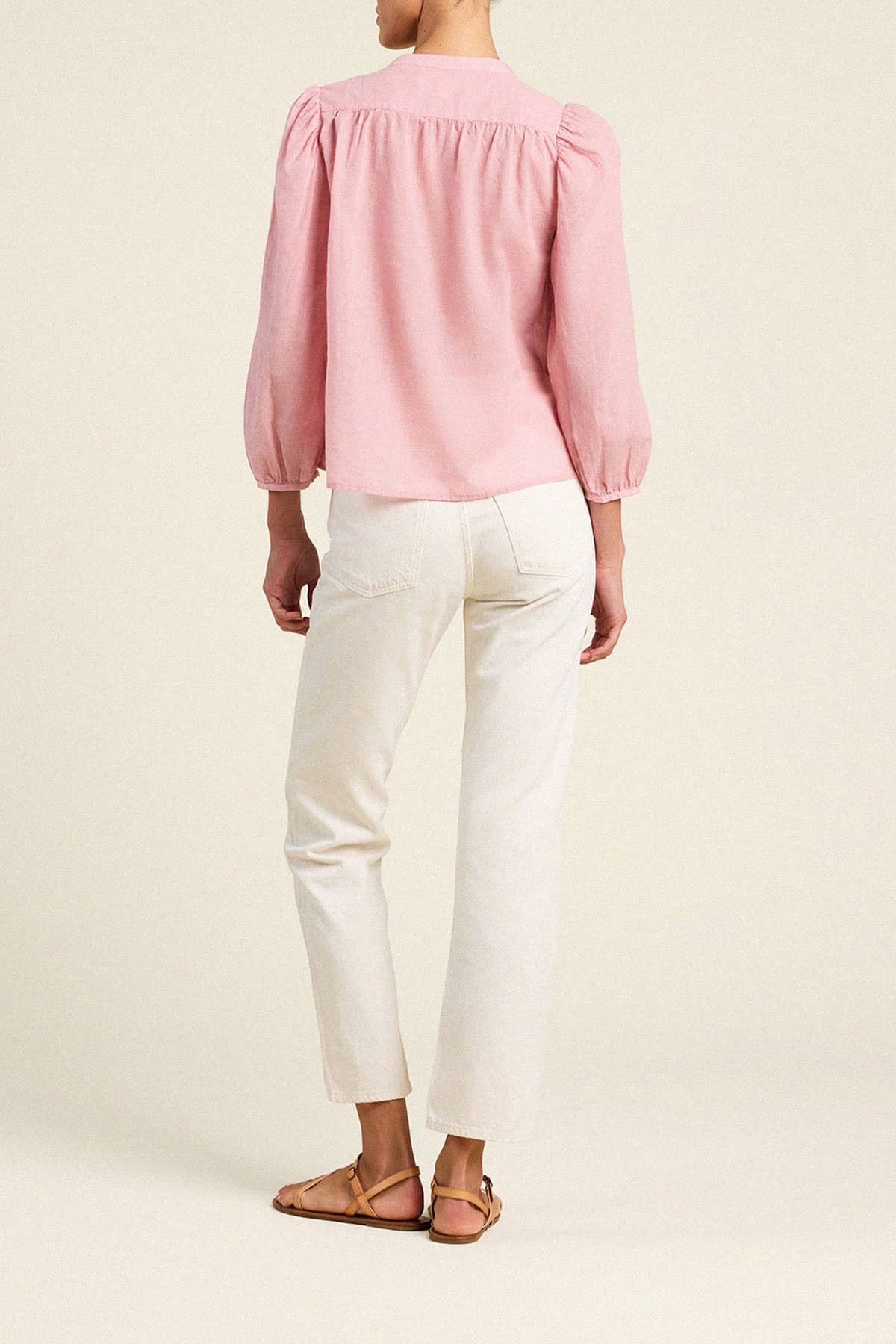 Trovata Maisey blouse in pink houndstooth with puffy sleeves and gathered detail, shown from back view with white jeans.