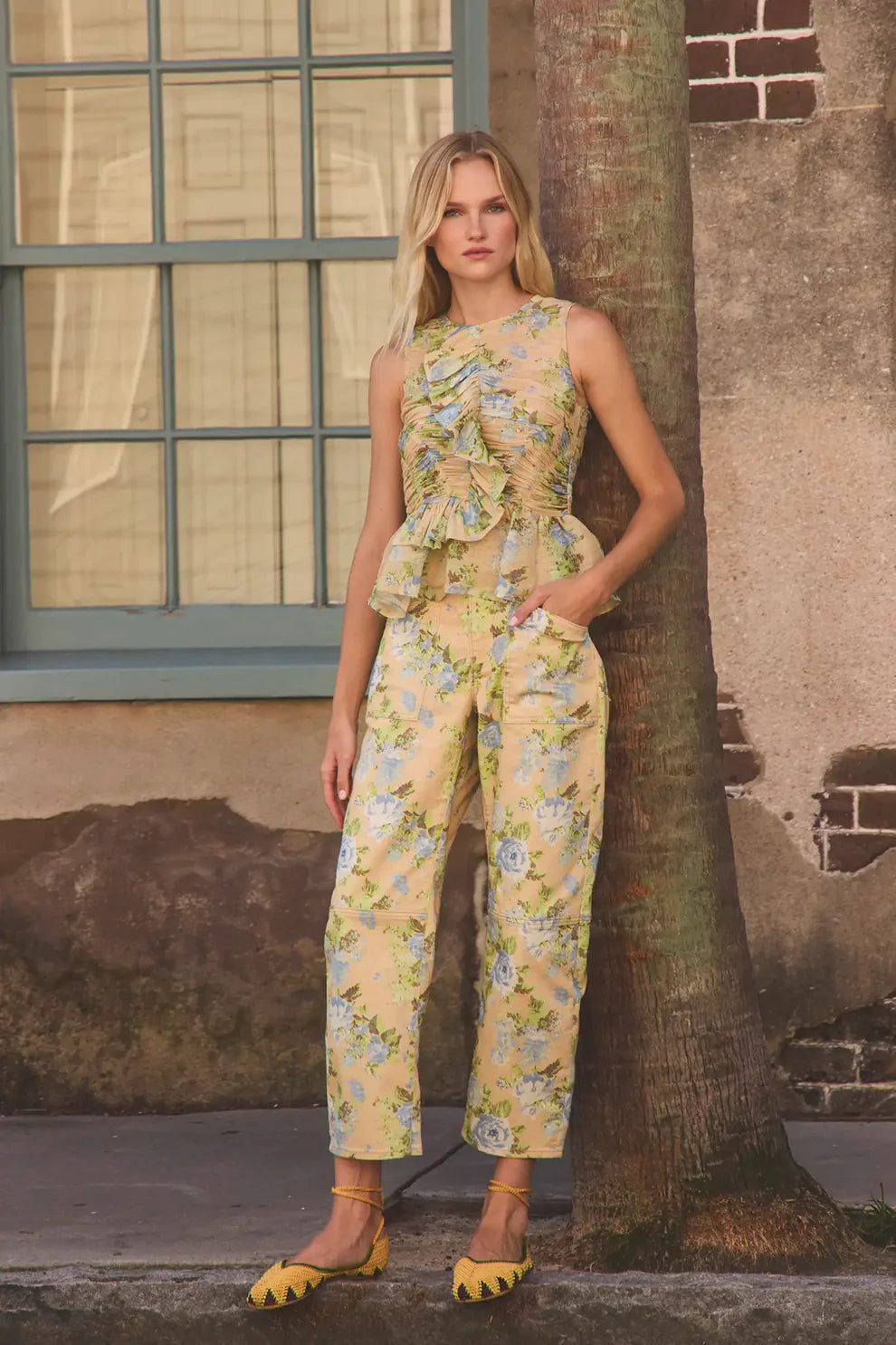Hunter Bell Mallory floral print jumpsuit with ruched sleeveless top and wide-leg pants styled with yellow woven flats.