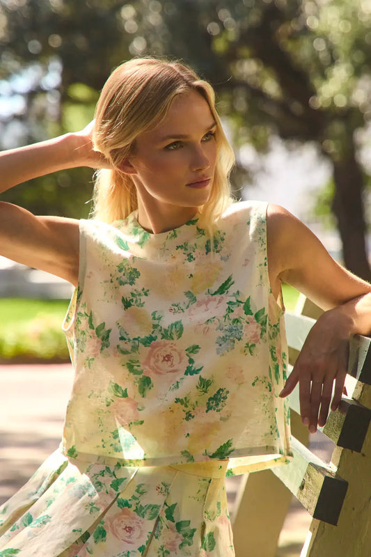Hunter Bell Manning sleeveless floral top featuring rose and peony print, worn by woman in natural outdoor setting.