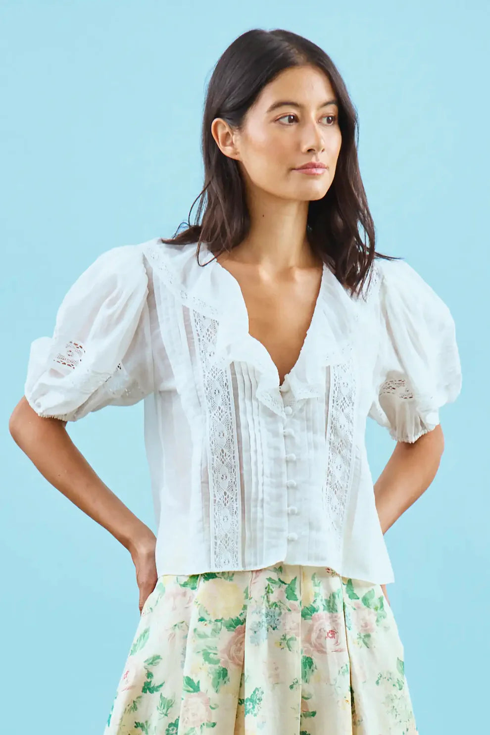 Hunter Bell Mare white cotton blouse with lace detailing, puffed sleeves, and button-front closure on model