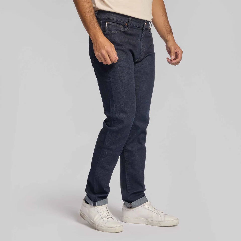 Man wearing Rye 51 Candiani Italian stretch selvedge denim jeans with cuffed hem and white sneakers