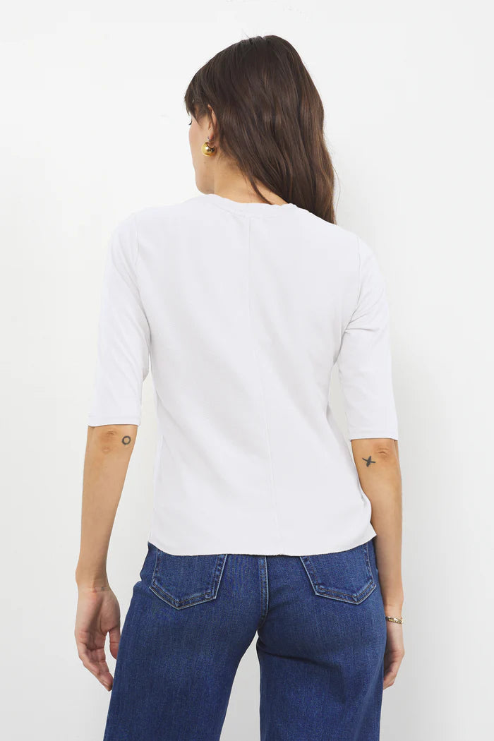 LAmade Santa Monica white elbow-length tee shirt shown from back, worn with blue jeans by model with dark hair