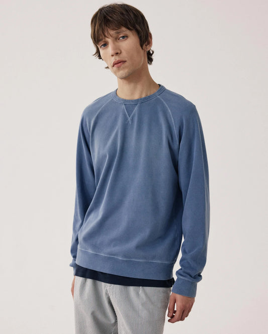 Model wearing Hartford Light Fleece crew neck sweatshirt in blue denim wash with relaxed fit styling.