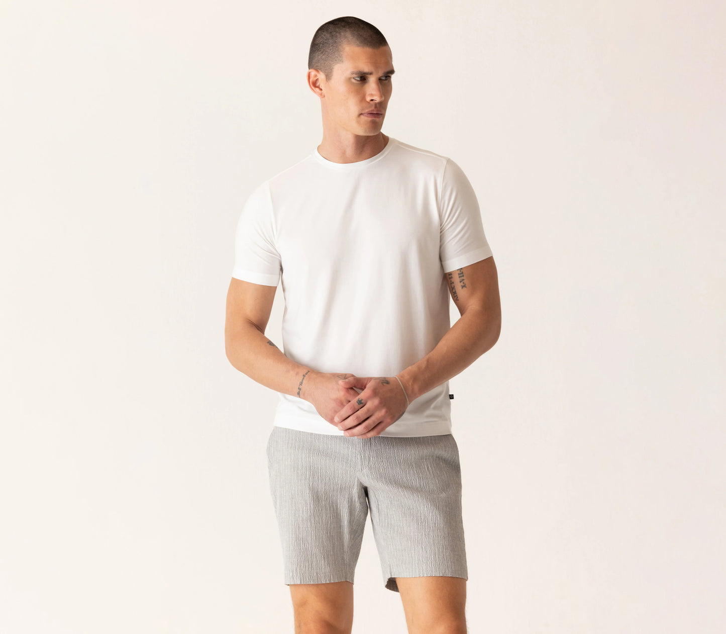 Man wearing Deke SS Modern crew neck t-shirt in optic white with gray shorts, displaying casual summer style.