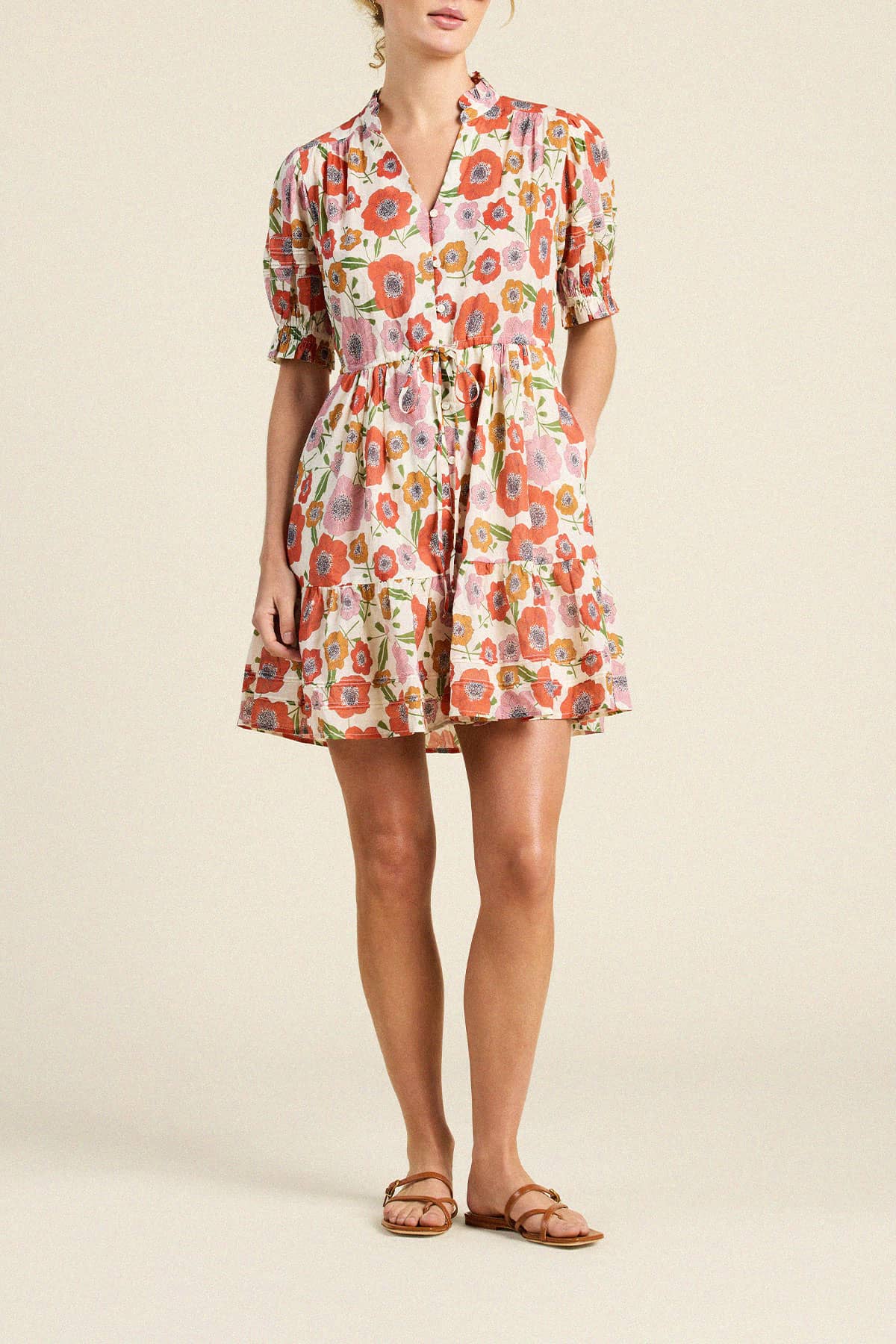 Trovata Phoebe floral print mini dress with puffed sleeves, tiered skirt, and button-front closure on model