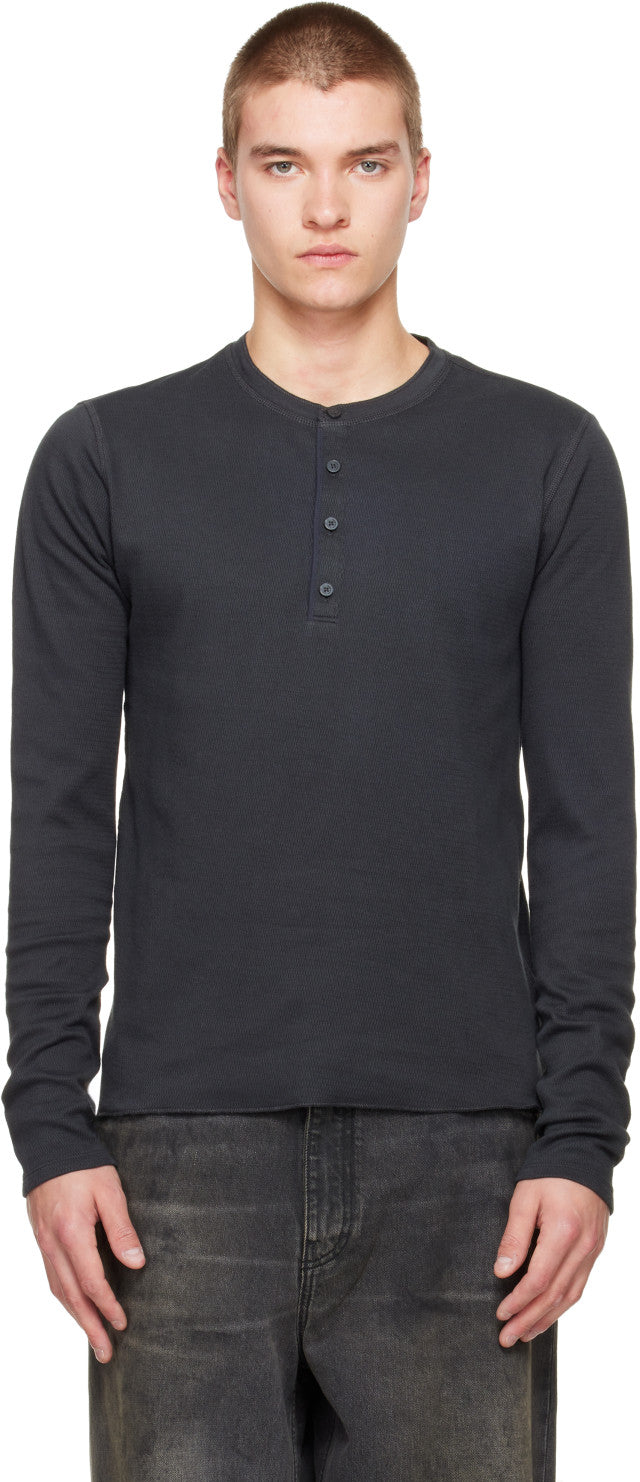 Male model wearing black long-sleeve henley with button placket and ribbed texture