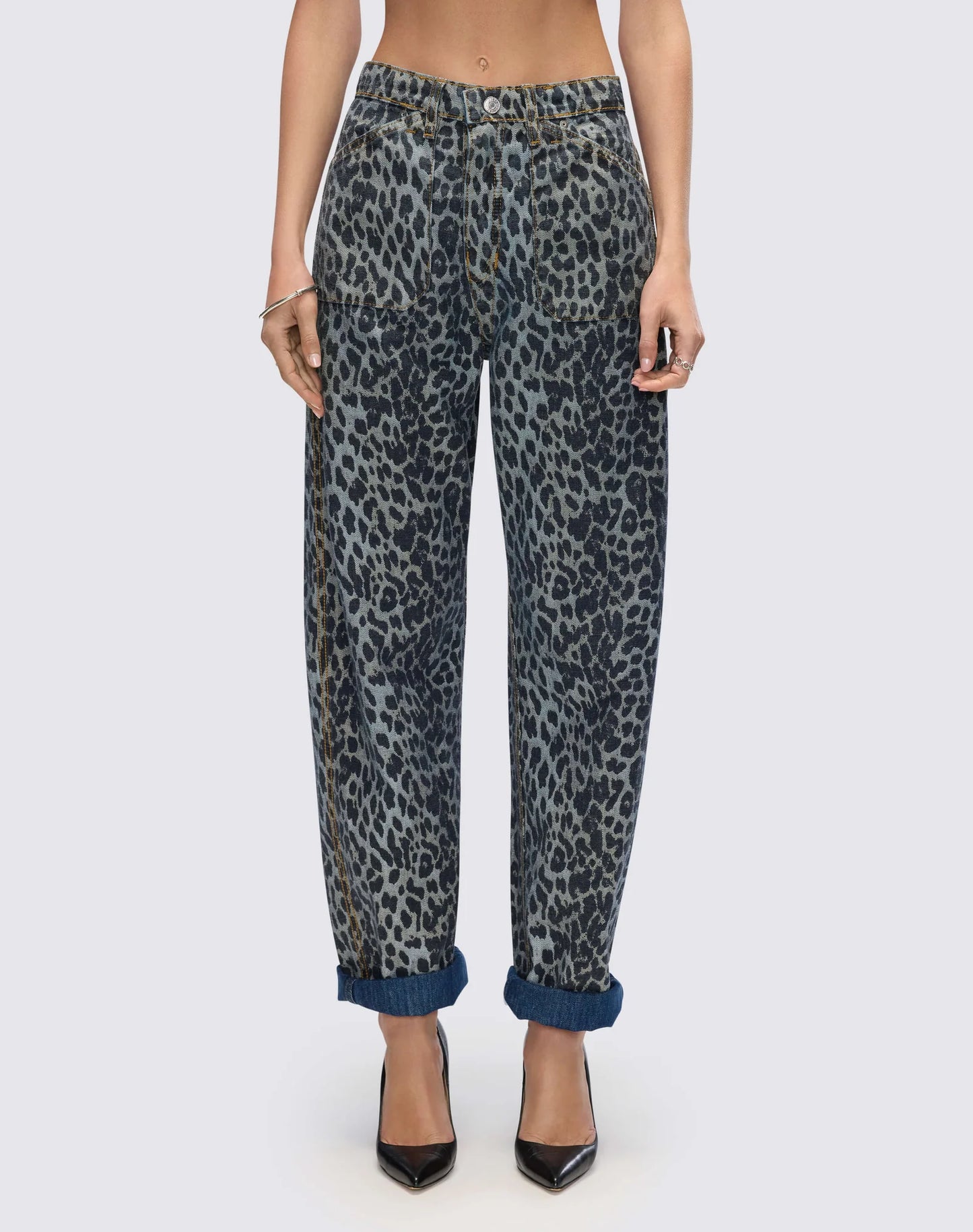 Re/Done high-waisted leopard print jeans with cuffed hems, worn with black pointed toe heels