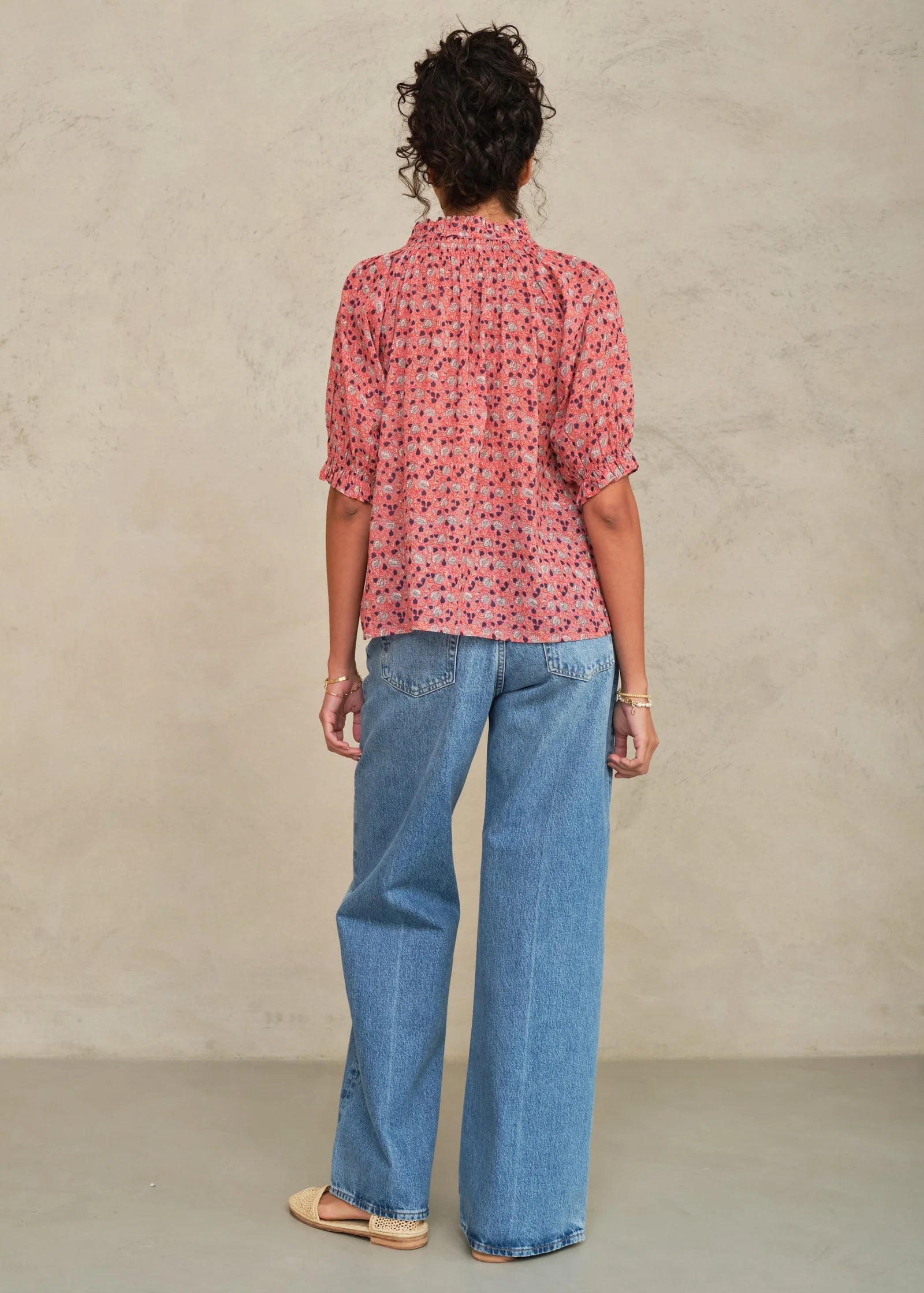 MABE Darla Print long sleeve top in rose floral pattern, shown from behind with wide-leg jeans.