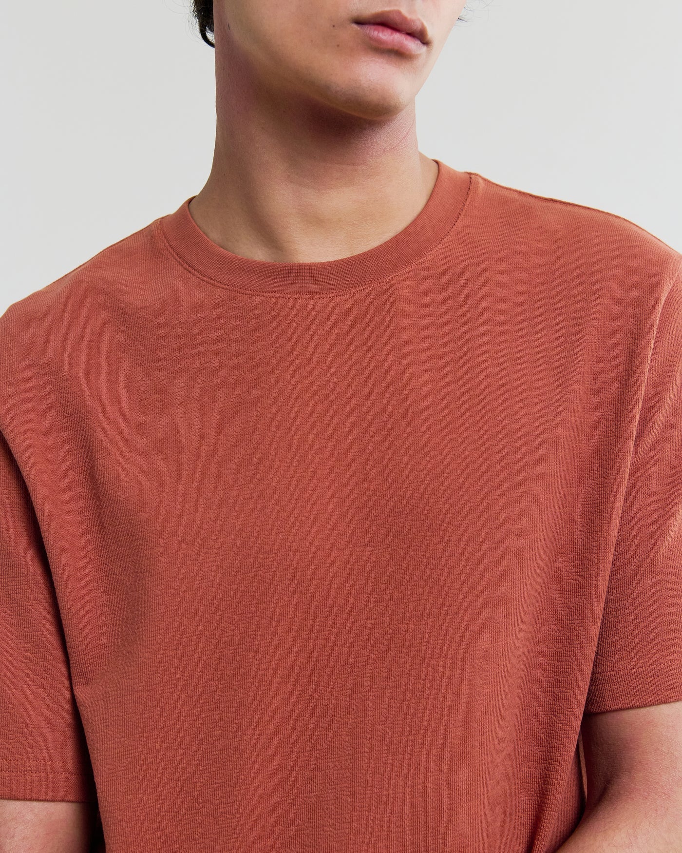 Wax London Dean short sleeve t-shirt in rust orange, shown on model against neutral background