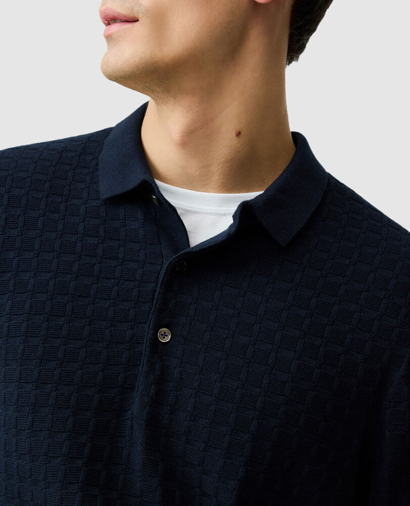 Man wearing navy textured knit polo sweater with collar and button placket from Rodd & Gunn