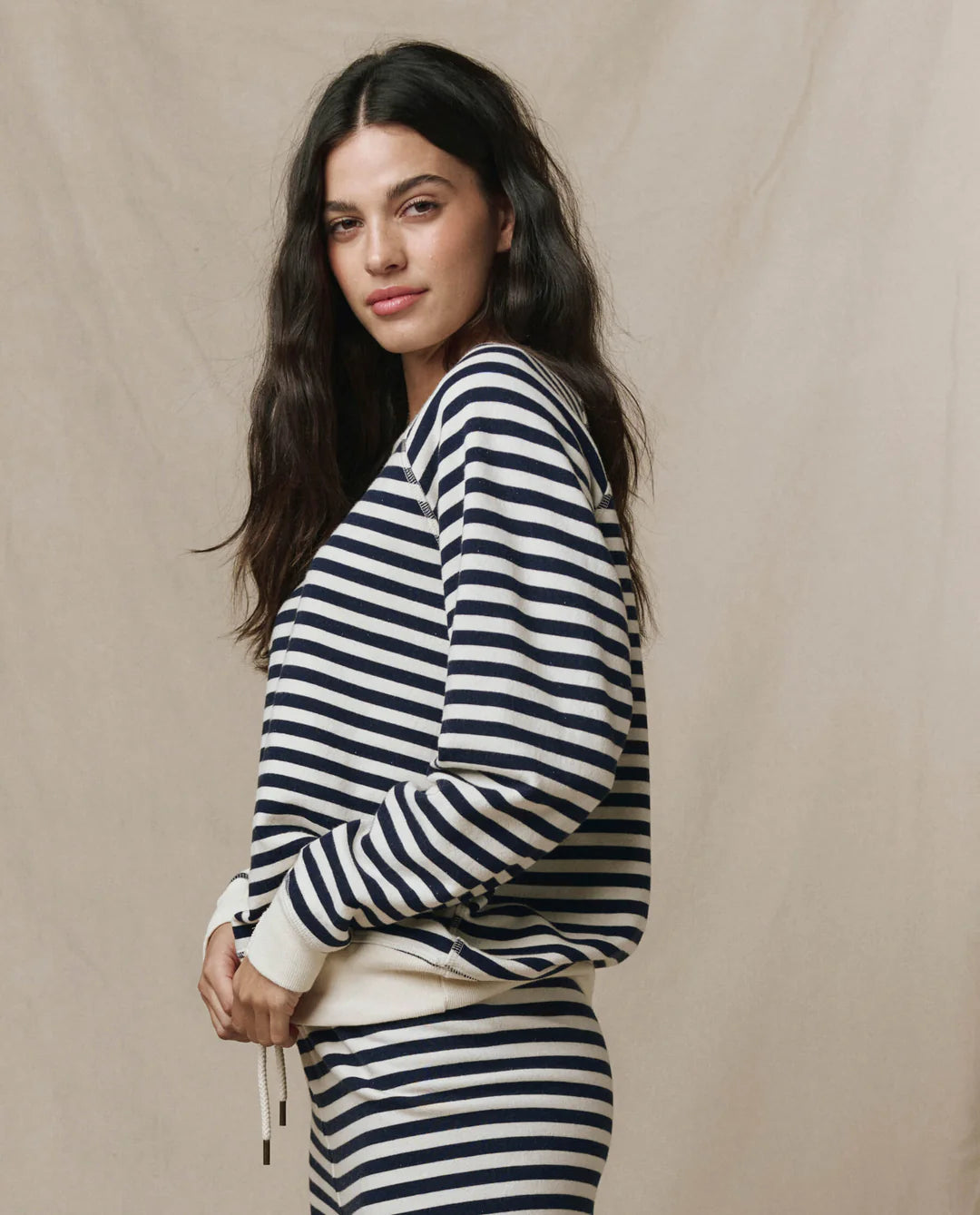 Woman wearing The GREAT College Sweatshirt in navy and white sailor stripes with relaxed oversized fit.