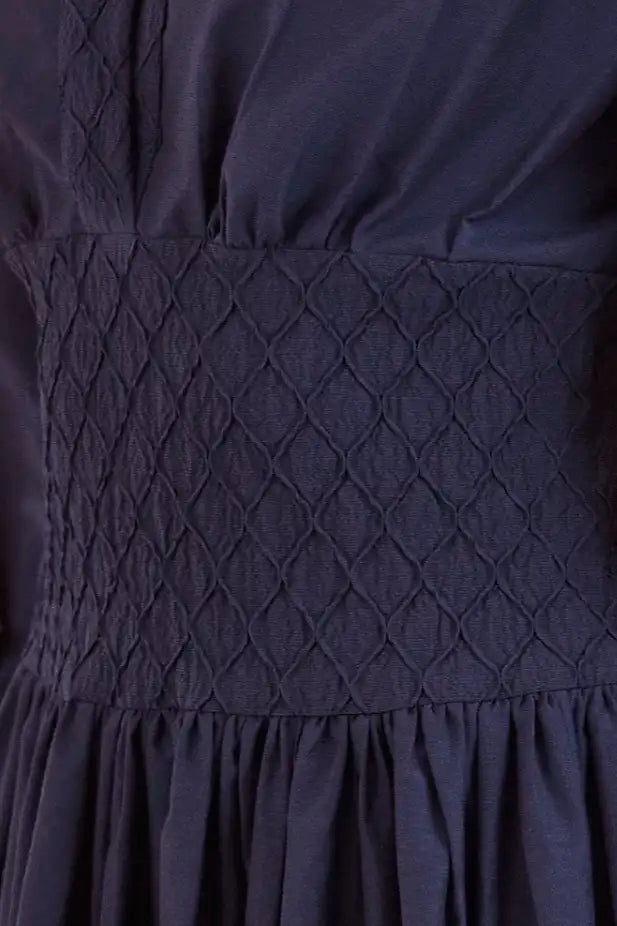 Hunter Bell Siri navy dress featuring diamond quilted bodice detail and gathered skirt with flowing fabric.