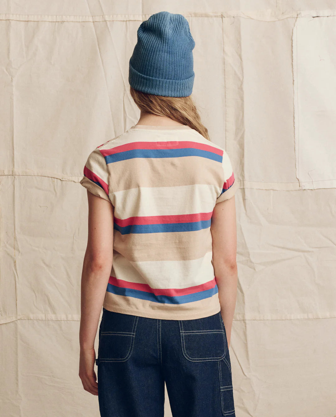 The Great striped short-sleeve tee with horizontal red, blue and neutral stripes shown from behind