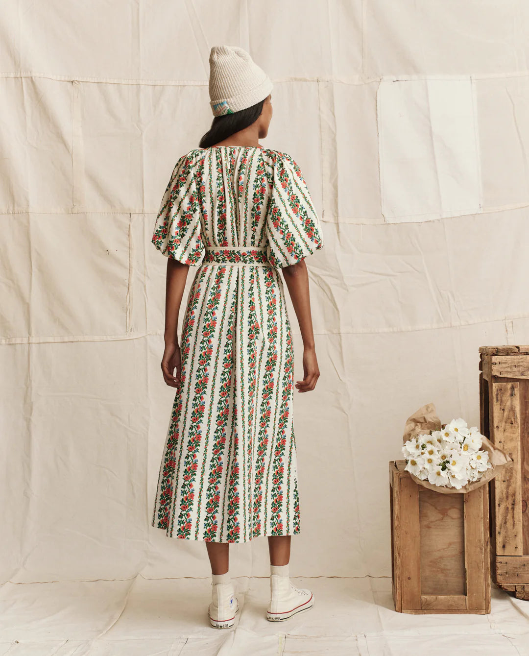 Woman wearing The Great The Fairground Dress in Tapestry Floral print with puffed sleeves and midi length, shown from behind.