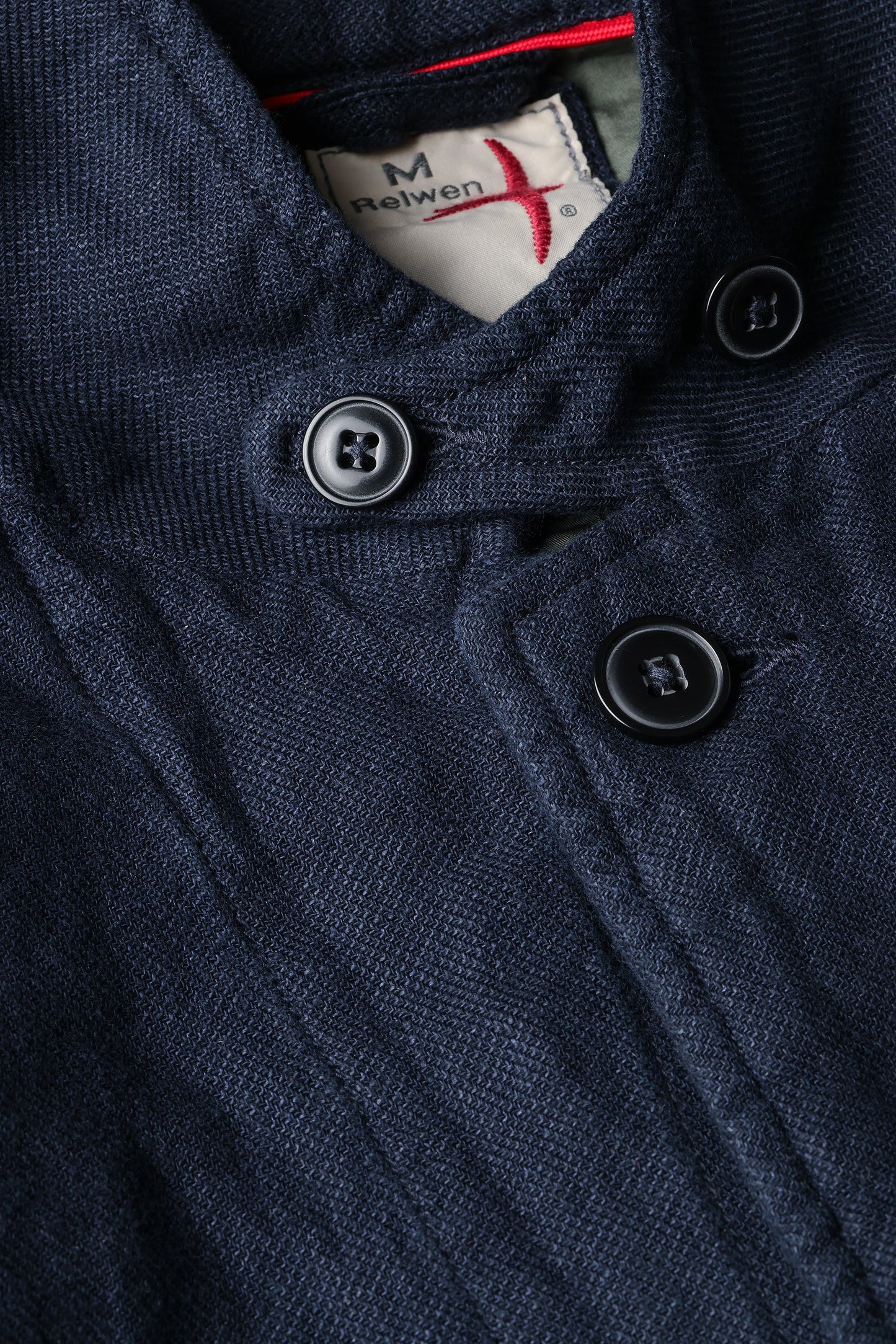 Relwen navy hopsack blazer detail showing textured fabric, dark buttons, and brand label at collar