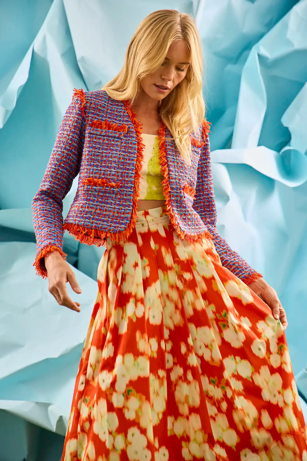 Hunter Bell Coco Jacket in blue and red mariner tweed with fringe trim details worn open over floral skirt.