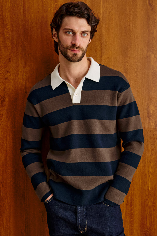 Male model wearing navy and brown striped rugby polo with cream collar