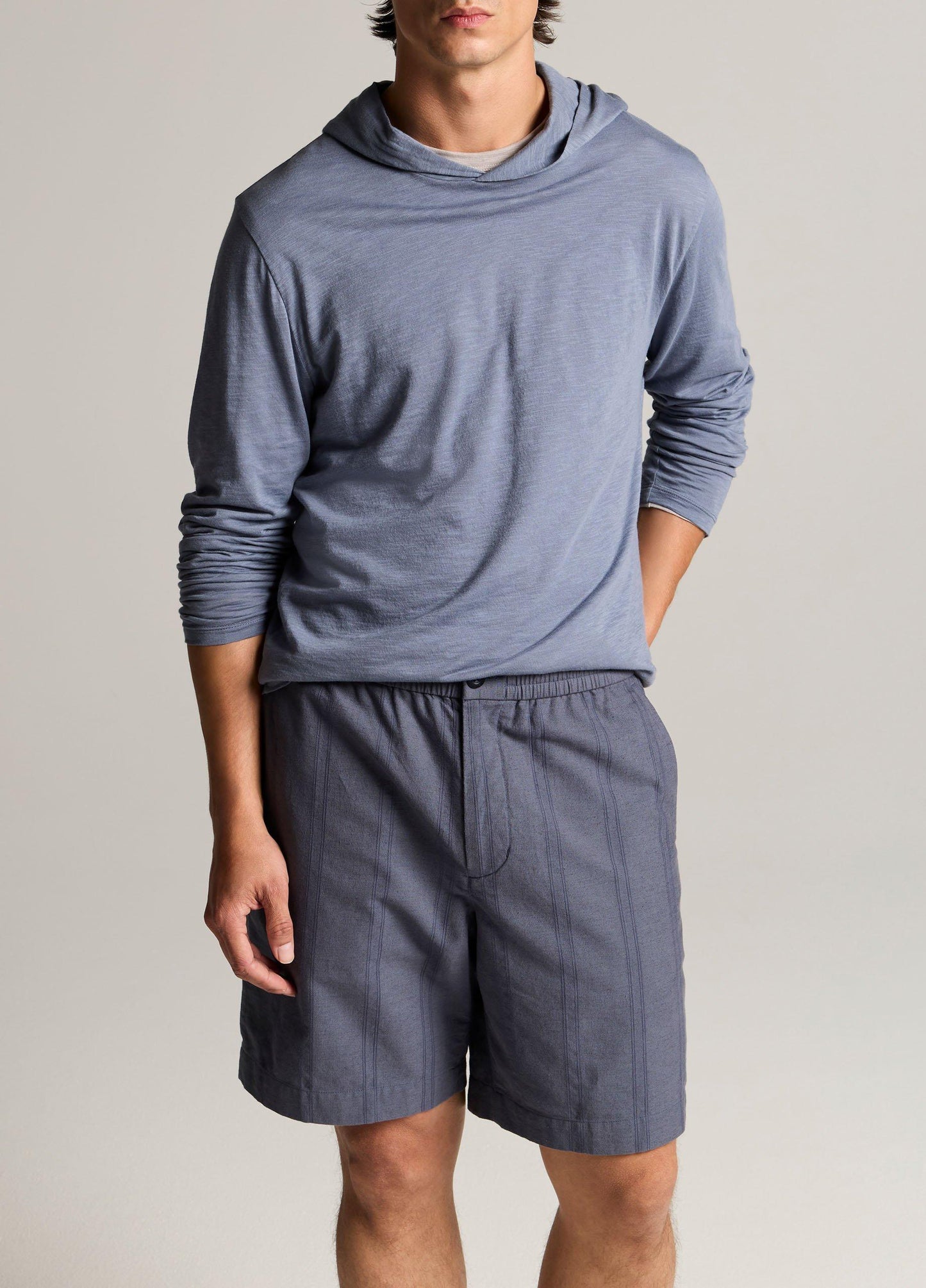 Male model wearing a blue long-sleeve slub pima cotton double-layer hoodie with shorts