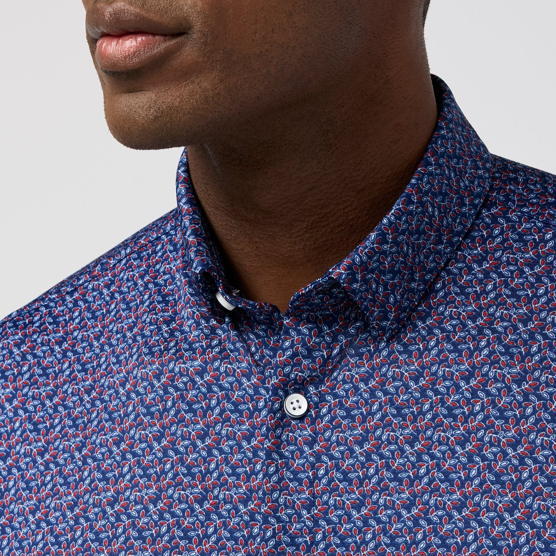 Mizzen + Main short sleeve button-up shirt featuring small red and white leaf pattern on navy background